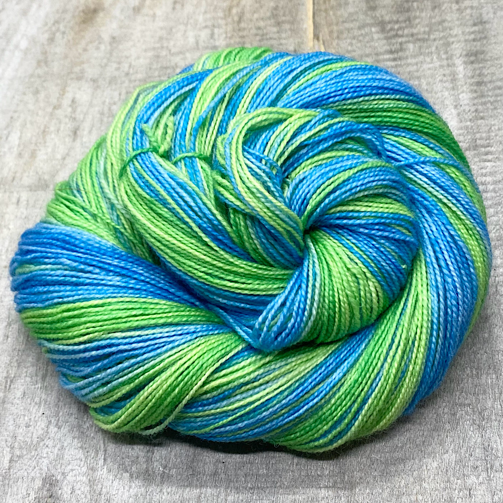 Photo of a skein of yarn, arranged in a swirl, hand dyed in colour: Glorious
