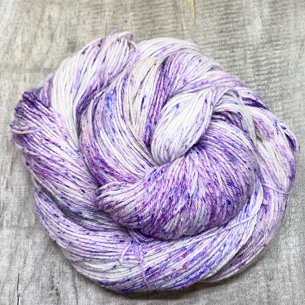 A hand-dyed skein of wool in colour 'violets' - a speckled dye type