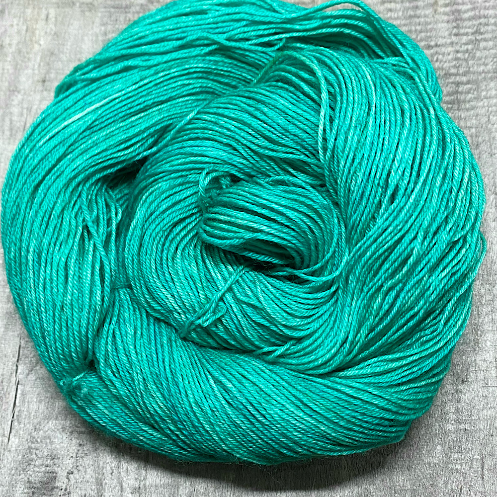 A skein of hand dyed yarn, shown swirled into a circle